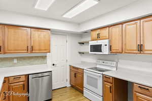 Kitchen featuring white appliances and light hardwood / wood-style flooring