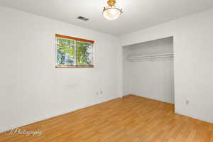 Unfurnished bedroom with a closet and light wood-type flooring