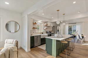 Kitchen featuring white cabinetry, plenty of natural light, stainless steel appliances, and pendant lighting