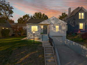 View of front of home with a garage and a yard