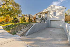 View of front of property with a garage and a front lawn