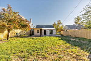 Back of property with a yard and a patio area