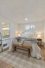 Bedroom with hardwood / wood-style flooring and a textured ceiling