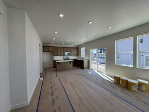 Kitchen with baseboards, stainless steel appliances, recessed lighting, and a center island