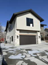 View of front of property with a garage and central air condition unit