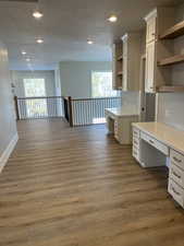 Kitchen with dark hardwood / wood-style floors, built in desk, white cabinets, and a textured ceiling