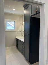 Bathroom with vanity, tile patterned flooring, and a textured ceiling