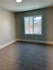 Carpeted empty room featuring a textured ceiling