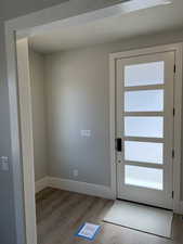 Doorway to outside with hardwood / wood-style flooring and plenty of natural light