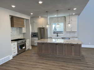 Kitchen with custom exhaust hood, white cabinetry, a center island, high quality appliances, and dark hardwood / wood-style floors