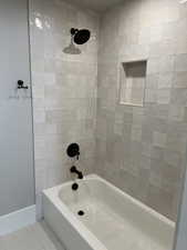 Bathroom with tiled shower / bath and tile patterned floors