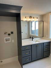 Bathroom with vanity, tile patterned flooring, and a textured ceiling