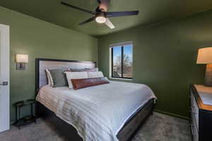 Bedroom with dark colored carpet and ceiling fan