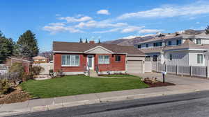 View of front of home with a garage and a front yard