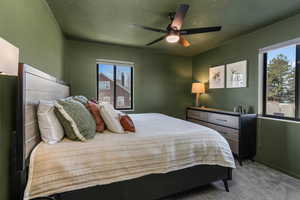 Carpeted bedroom featuring ceiling fan