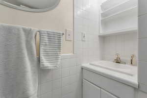 Bathroom with vanity and tile walls