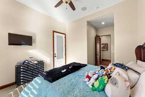 Carpeted bedroom featuring ceiling fan