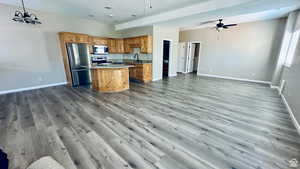 Kitchen with a kitchen island, ceiling fan with notable chandelier, sink, hanging light fixtures, and stainless steel appliances