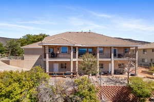 Back of property featuring a balcony and a patio area