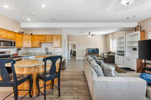 Kitchen featuring appliances with stainless steel finishes, a breakfast bar, sink, a center island, and light hardwood / wood-style floors