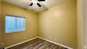 Spare room featuring wood-type flooring and ceiling fan