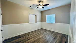 Spare room with dark hardwood / wood-style flooring and ceiling fan