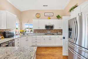 Kitchen with sink, stainless steel appliances, and white cabinets