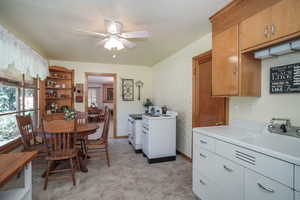 Dining room with washer and dryer, sink, and ceiling fan