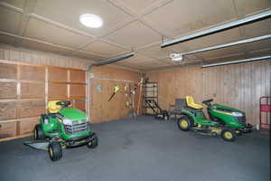 Garage featuring a garage door opener and wood walls