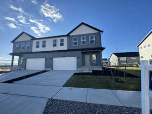 View of front of property with a garage and a front yard