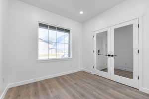 Spare room featuring french doors and light hardwood / wood-style floors