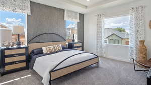 Carpeted bedroom with multiple windows and a tray ceiling