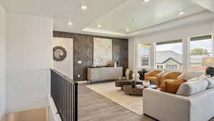 Living room with a tray ceiling and wood-type flooring