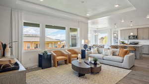 Living room with dark hardwood / wood-style flooring, a chandelier, a raised ceiling, and a textured ceiling