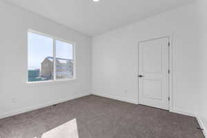 Unfurnished room featuring dark colored carpet