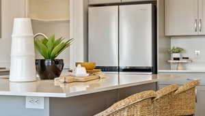 Kitchen featuring white cabinetry and stainless steel refrigerator