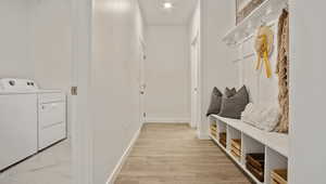 Mudroom with separate washer and dryer and light hardwood / wood-style flooring