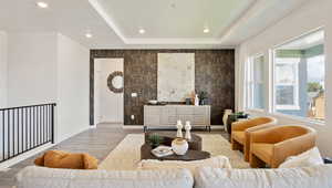 Living room with a raised ceiling and hardwood / wood-style floors