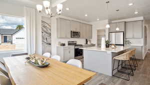 Kitchen featuring hanging light fixtures, appliances with stainless steel finishes, and gray cabinetry