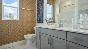 Bathroom with vanity, a healthy amount of sunlight, and toilet