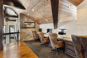 Office area with vaulted ceiling with beams, wood ceiling, wood-type flooring, and built in desk