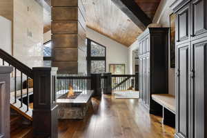 Interior space featuring wood ceiling, high vaulted ceiling, and dark wood-type flooring