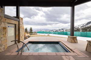 View of pool featuring a patio, a mountain view, and a community hot tub