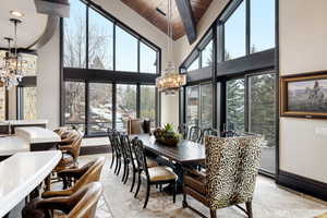 Dining room with wood ceiling, a chandelier, and a high ceiling