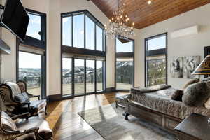 Bedroom with wood ceiling, a mountain view, light hardwood / wood-style floors, and a wall unit AC