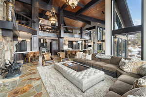 Living room featuring an inviting chandelier, beamed ceiling, high vaulted ceiling, and wooden ceiling