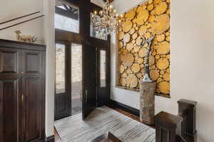 Foyer with a notable chandelier and wood-type flooring