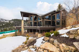 Snow covered house featuring a deck with mountain view