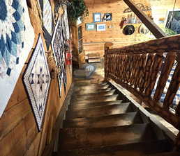 Staircase featuring wood-type flooring and wooden walls leading down to great room