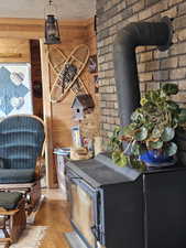 Interior space featuring wooden walls, light hardwood / wood-style floors, and a wood stove